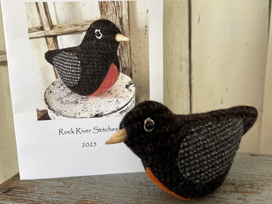 Primitive Wool Robin pattern cover beside a stitched black wool robin